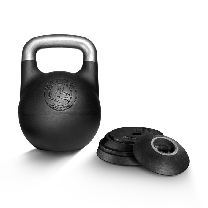 A Bells of Steel Adjustable Competition Kettlebell with a metallic handle stands beside four stacked black weight plates on a white background. The kettlebell displays an embossed logo on its front.