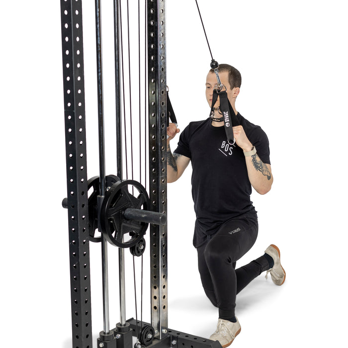 A person kneels on one knee, performing a cable exercise with Bells of Steel Adjustable Length Aluminum Handles attached to a cable machine against a plain white background.
