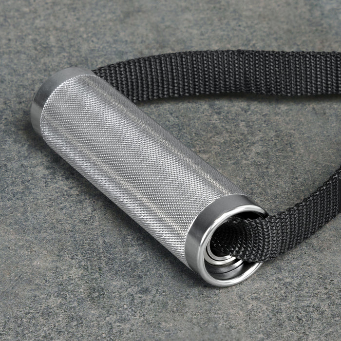 The Bells of Steel USA Aluminum Handles Pair with Bearings, featuring a knurled grip and black woven strap, rests on a gray stone surface.