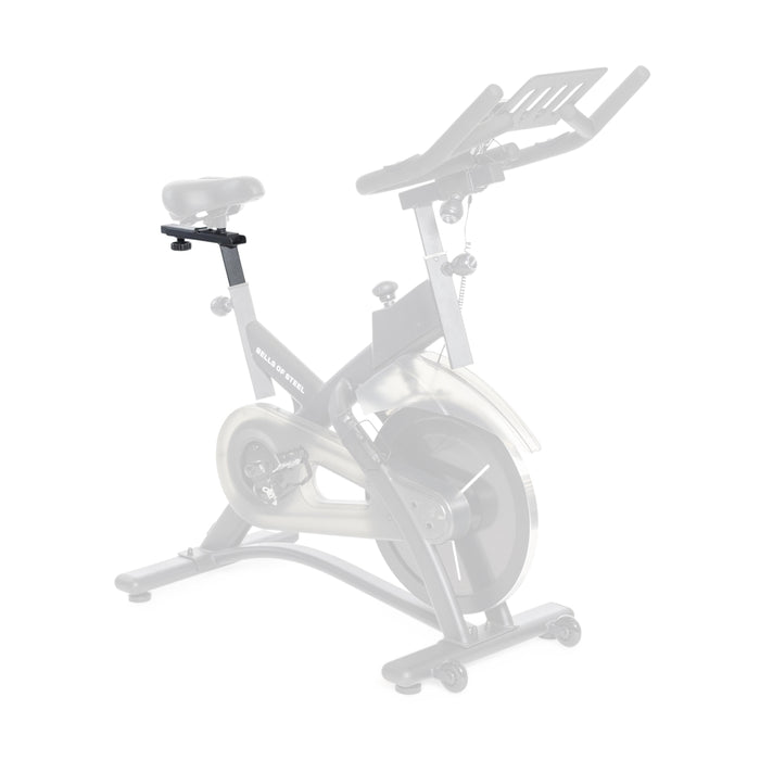The Bells of Steel USA Tall Cycling Bike Seat Post is shown installed on a stationary bike, making the seat noticeably higher than the original base model, which appears faded in the background for contrast.