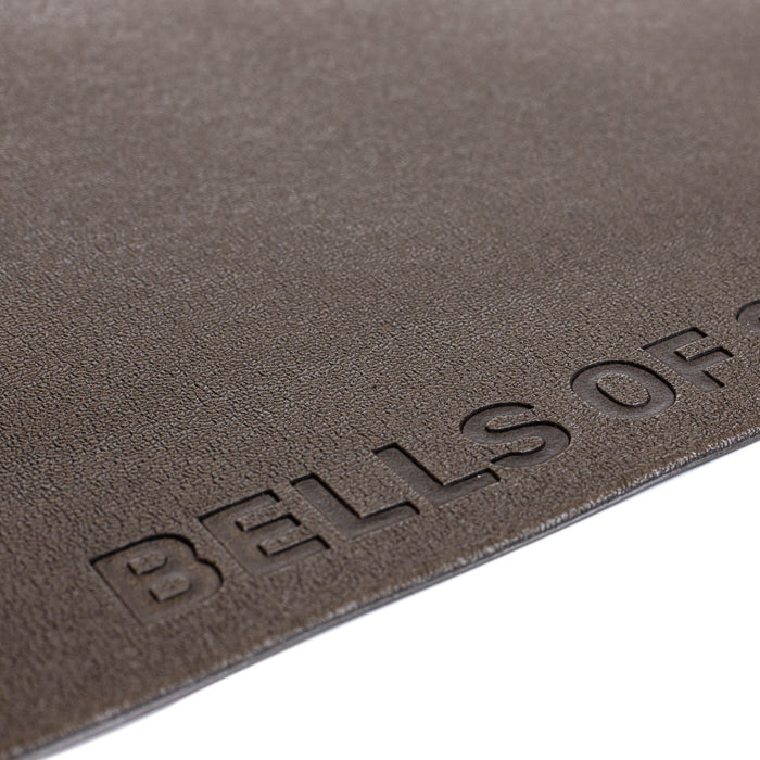Close-up of a textured brown Bells of Steel Cardio Machine Floor Mat surface, with the embossed "BELLS OF" logo partially visible in the lower right corner.
