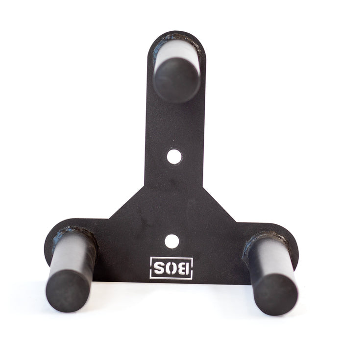 The Bells of Steel Change Plate Storage Pegs is a black metal wall mount bracket with three cylindrical pegs arranged in a triangle, ideal for organizing Olympic change plates. It features two mounting holes and an upside-down "SIS" logo at the bottom.
