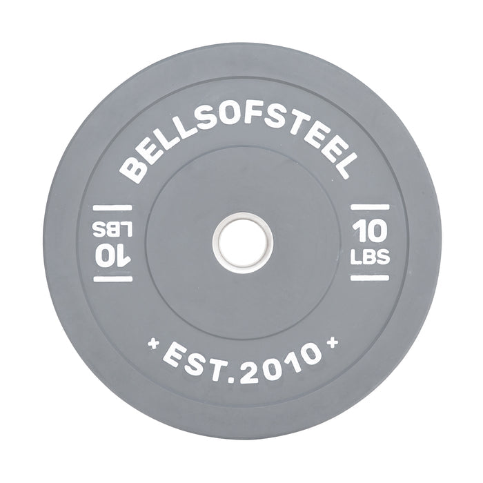 The Bells of Steel Colored Bumper Plates include a grey round design with "BELLSOFSTEEL" and "10 LBS" inscribed, plus "EST. 2010" at the bottom. Its stainless steel insert ensures accurate weight and a perfect fit on barbells.