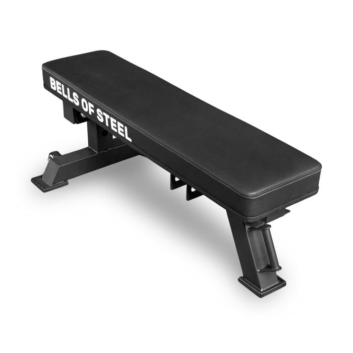 The Bells of Steel USA Converter Bench - Flat Bench is a black flat weight bench with "BELLS OF STEEL" in white, built to IPF competition height, featuring sturdy metal legs and a padded surface, shown on a white background.