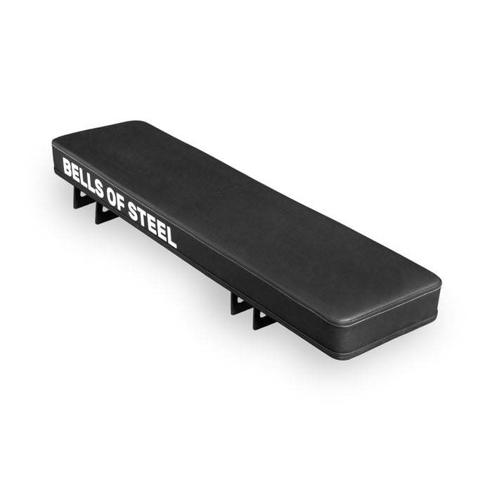 The Bells of Steel USA Converter Bench - Flat Bench is a black rectangular gym pad with "BELLS OF STEEL" in white on the side, designed for modular bench setups and shown on a white background.