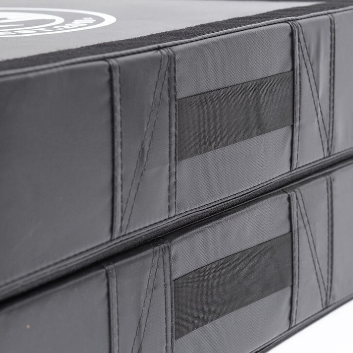 Close-up of two stacked Bells of Steel Deadlift Pads (Pair) in black, featuring reinforced stitching and side velcro strips for secure attachment and noise reduction during weightlifting.