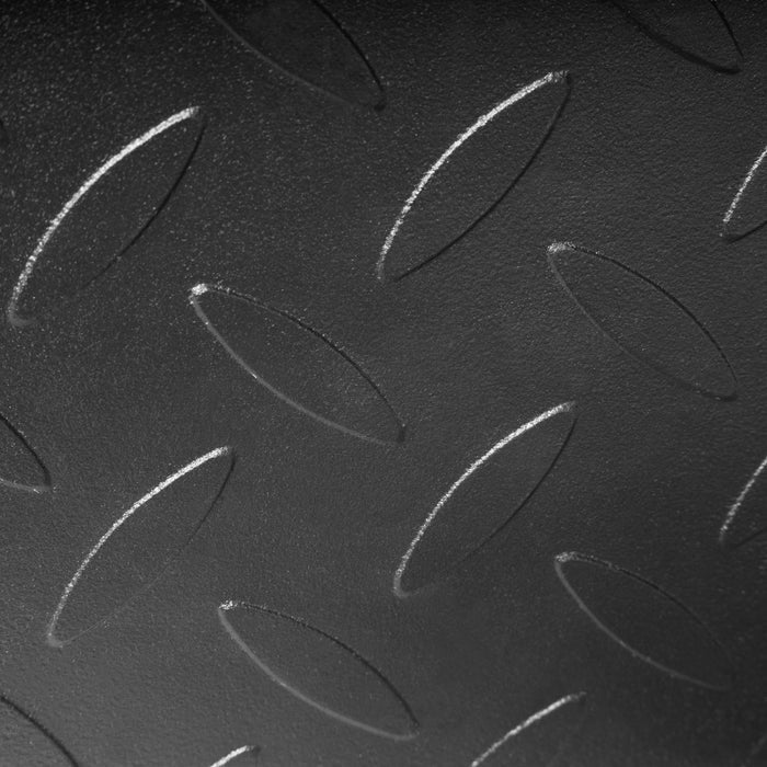 Close-up of a black metal Bells of Steel USA Footplate for Cable Tower/All In One Trainer, featuring a raised diamond plate pattern with repeating oval-shaped textured bumps.