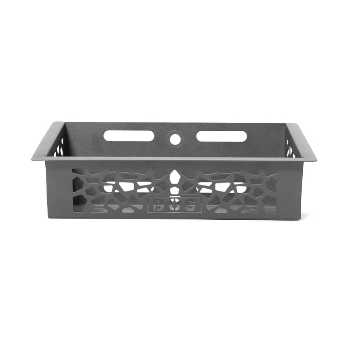 The Bells of Steel Rack Attached Storage Basket is a rectangular black metal basket with decorative cutouts, two horizontal slots, a round hole on the back, and a front center logo—ideal for gym storage.