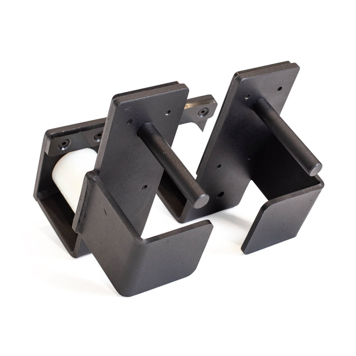 Two black metal Bells of Steel Roller J-Cups with horizontal rods are mounted side by side on a white background. One displays a white cylinder, showcasing the durable nylon rollers that enhance safety during bench presses.