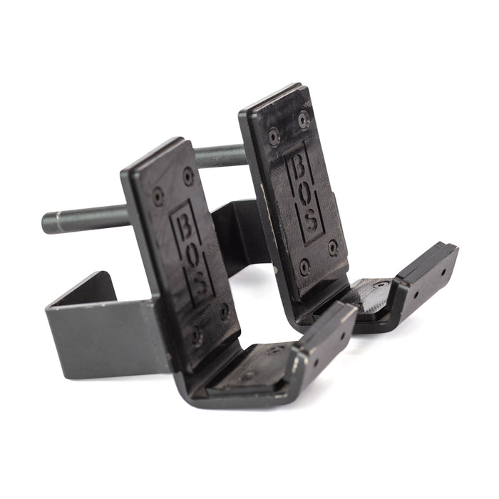 The Bells of Steel Standard J-Cups are black metal attachments for power racks, featuring "BOS" engraving, padded UHMW protection, and durable construction to securely support barbells during workouts.