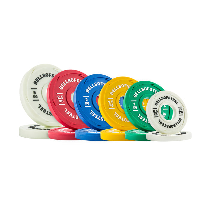 A set of vibrant Urethane-Coated Change Plates by Bells of Steel, in white, red, blue, yellow, and green, stand upright and slightly overlapping, each plate displaying the brand name and distinct kilogram values.