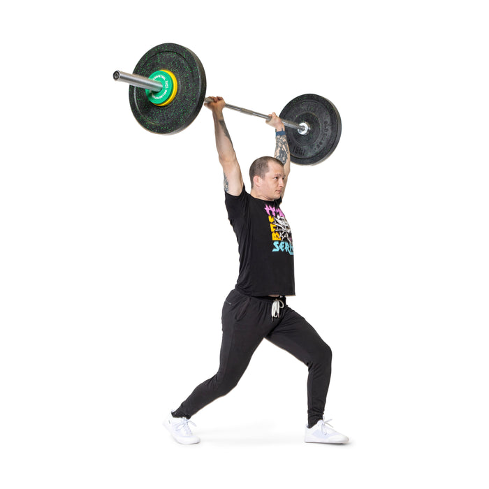 A person in a black T-shirt and pants performs a split jerk, lifting a barbell loaded with Bells of Steel Urethane-Coated Change Plates overhead against a white background.